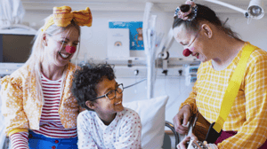 Sykehusklovnene – klovner spiller gitar for barn på sykehus