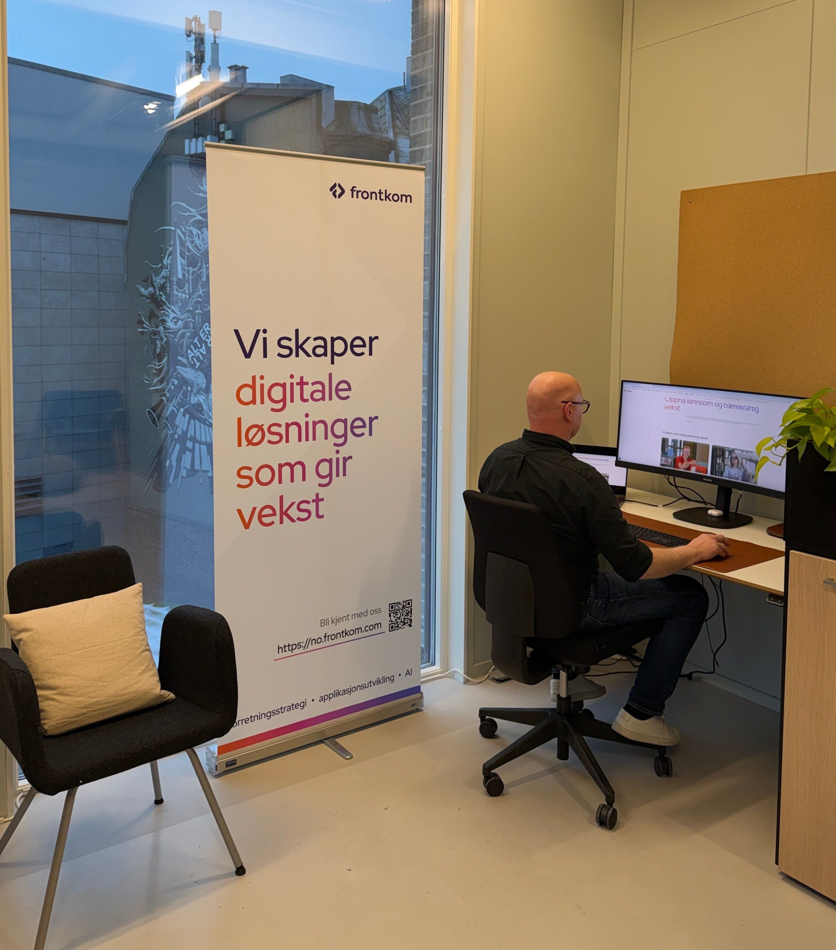 Plakat og en person som jobber ved en PC