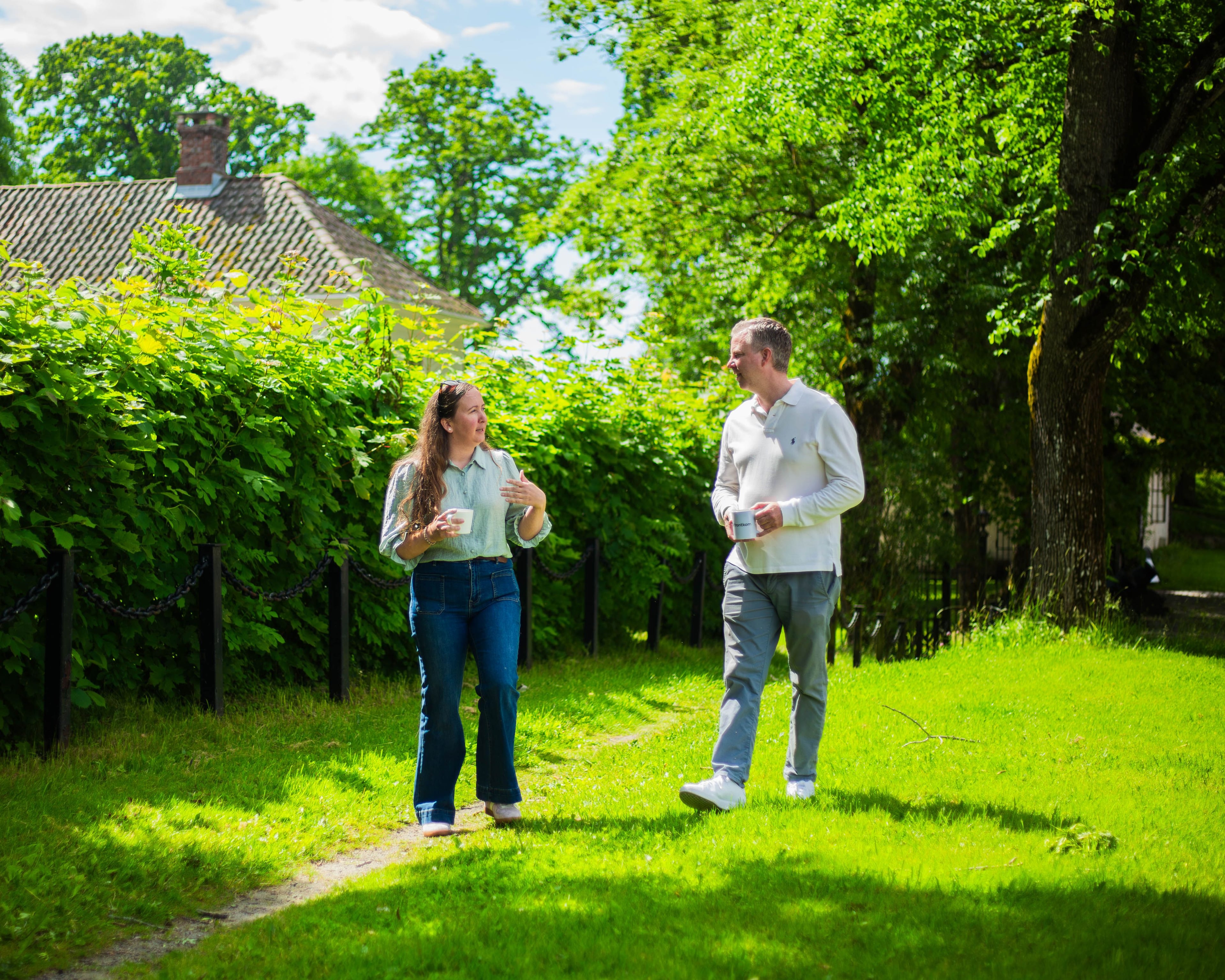 Two colleagues laughing together on the lawn