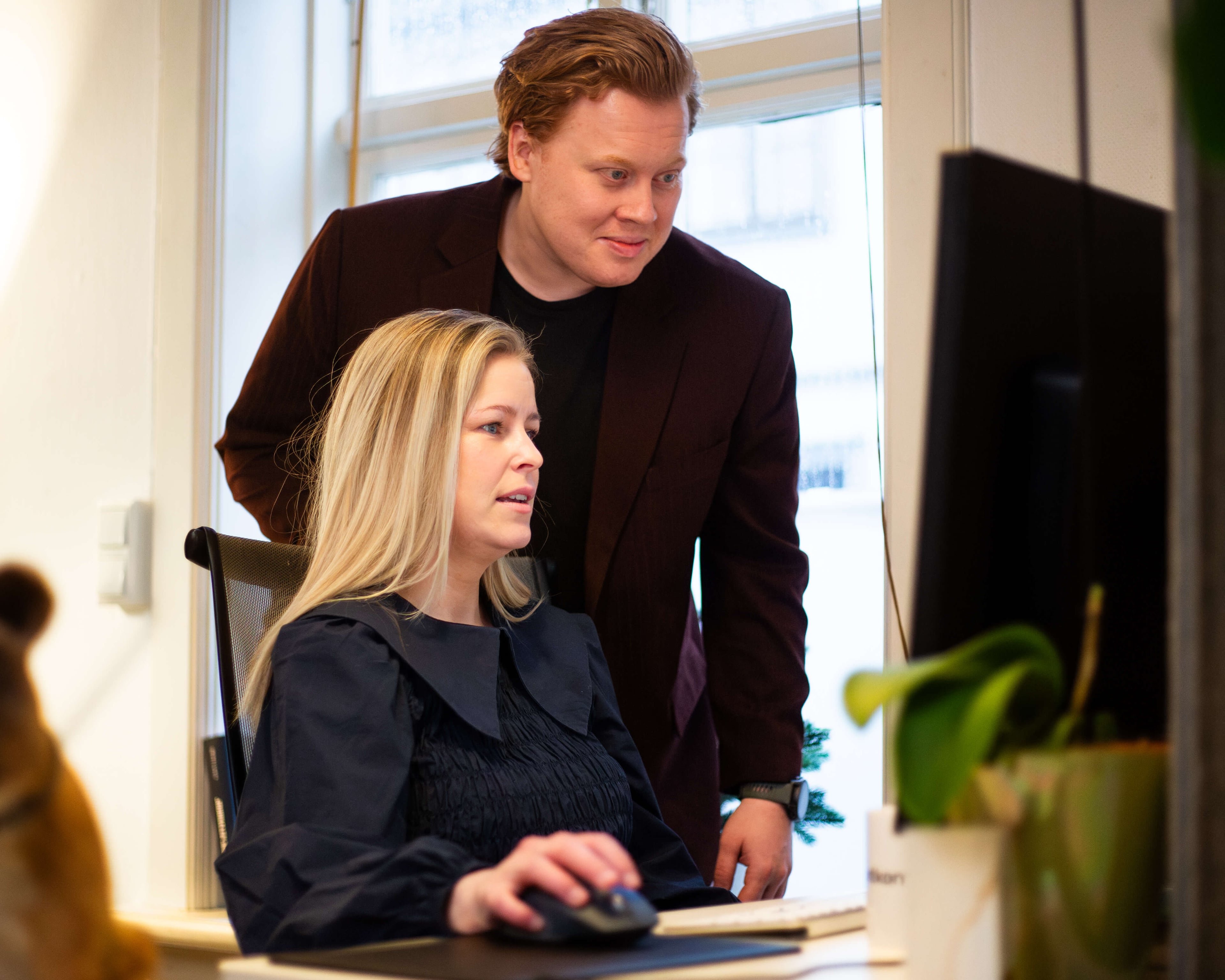 Two Frontkom colleagues working together in front of a computer screen