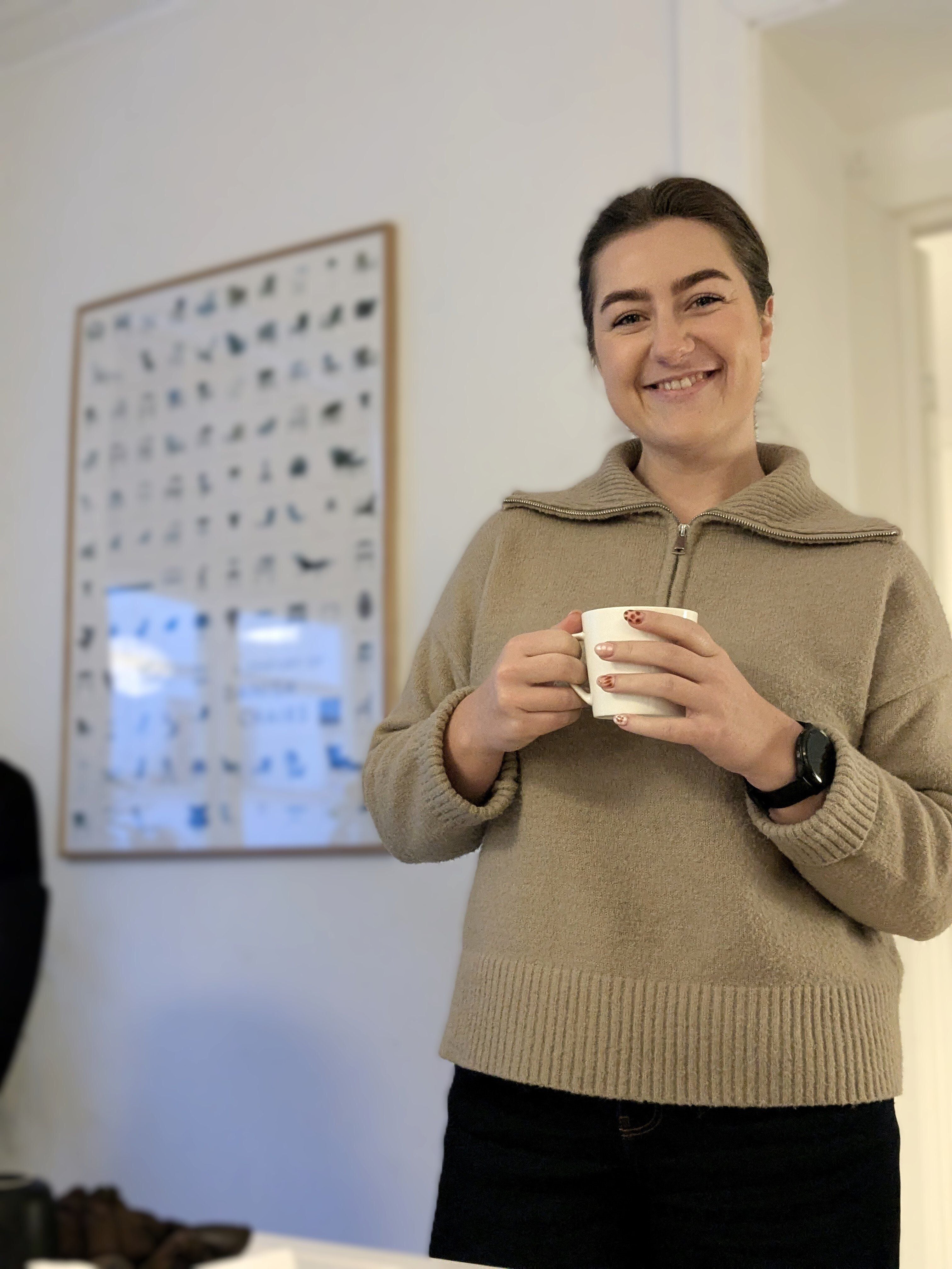 Person holding a coffee cup and smiling