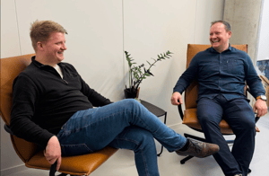 To personer som sitter og smiler